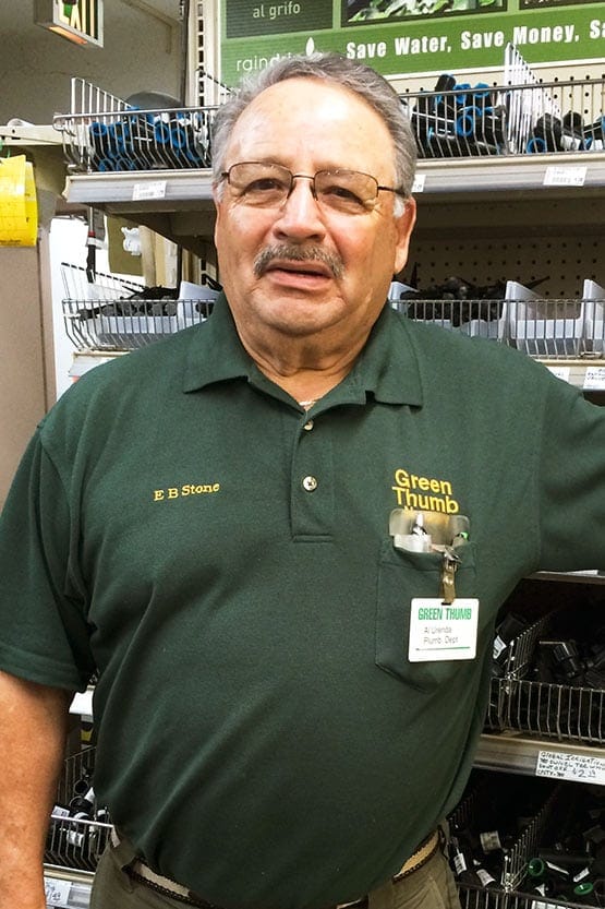 A man in a green shirt standing in a store.