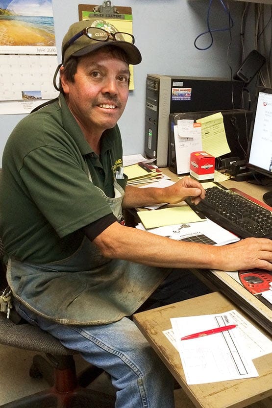A man sitting at a desk in front of a computer.
