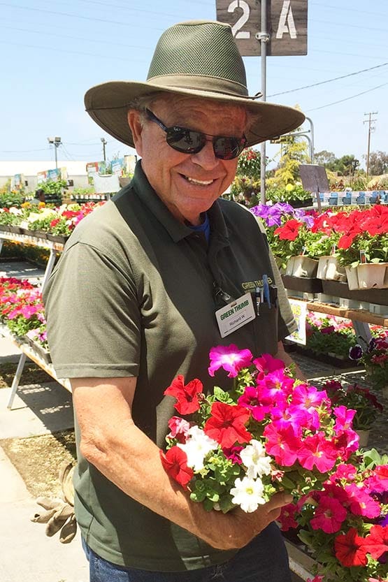 A man in a hat holding a bunch of flowers.