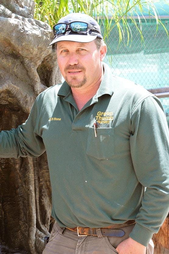 A man standing next to a waterfall in a zoo.