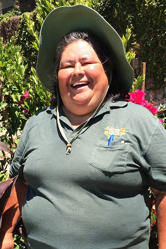 A woman wearing a green shirt and hat.