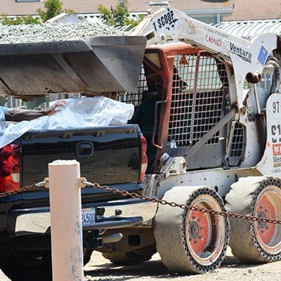 A man loading a truck with a load of concrete.