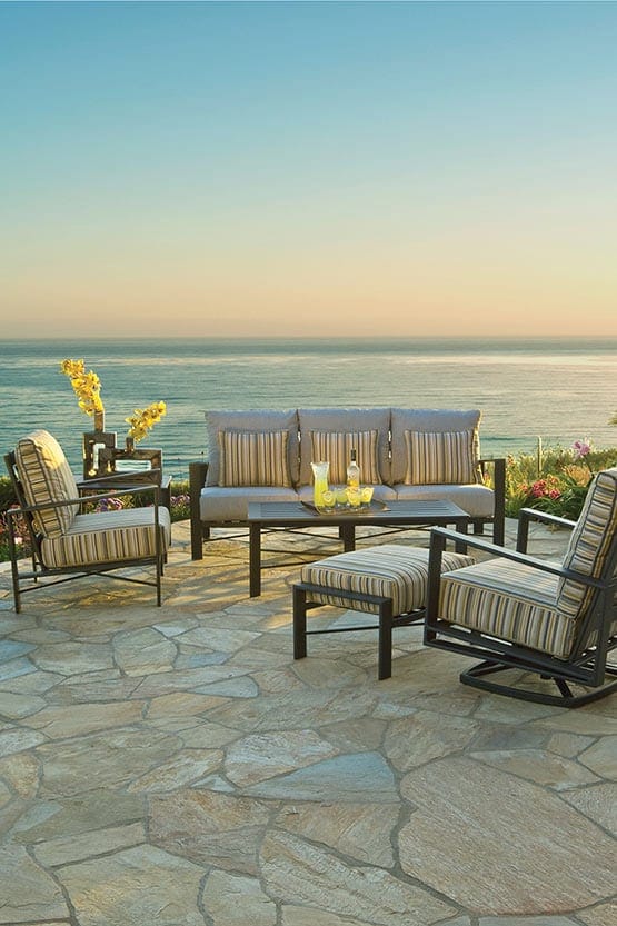 A patio furniture set with a view of the ocean.