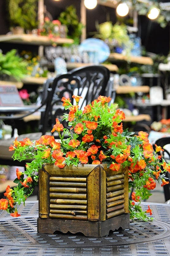 A wooden planter with orange flowers on it.
