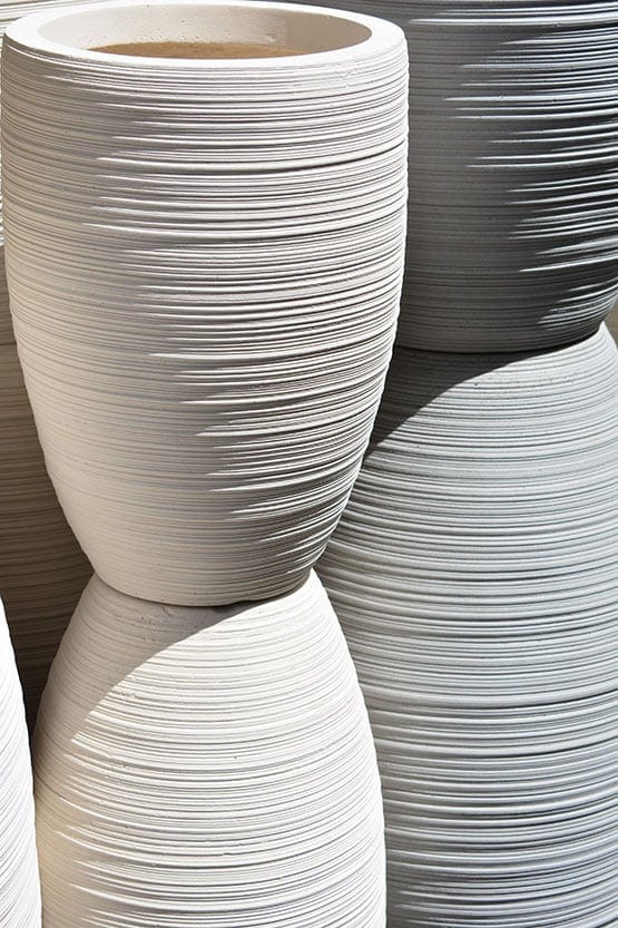A group of white ceramic pots stacked on top of each other.