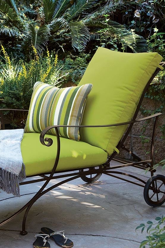A chaise lounge with a green cushion.