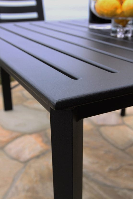 A black outdoor table with lemons on it.