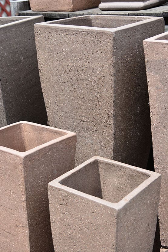 A group of concrete planters are stacked on top of each other.