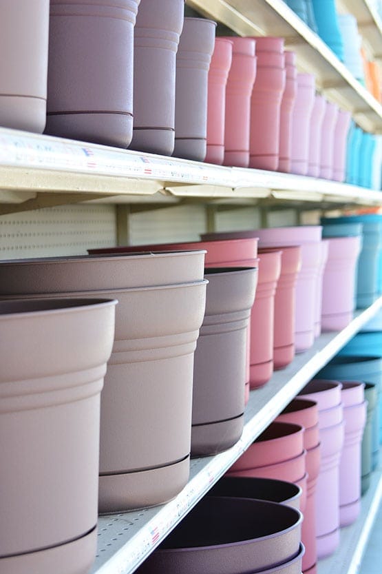 A row of colorful pots on a shelf in a store.