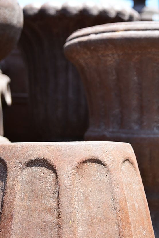 A group of terra cotta pots in a yard.