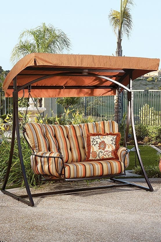 A patio swing with a cushion and a canopy.