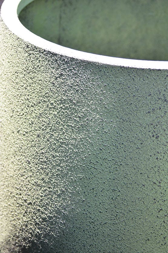 A close up of a green planter.