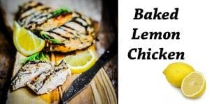 Baked lemon chicken with lemon slices on a cutting board.