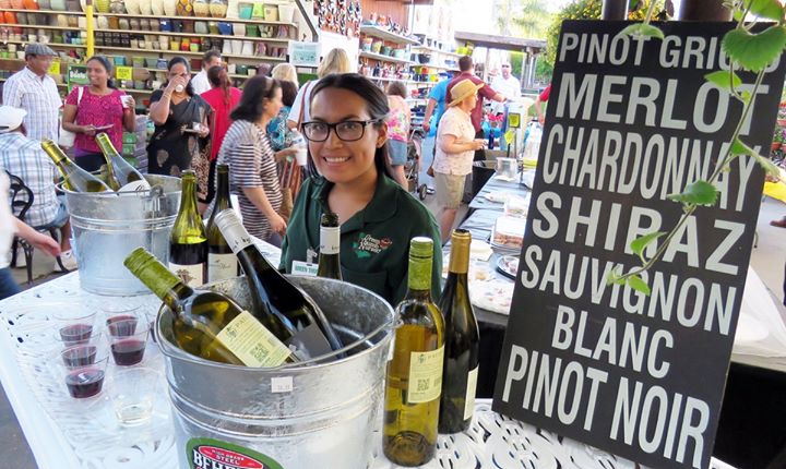 A woman is selling wine at an outdoor market in Southern California.