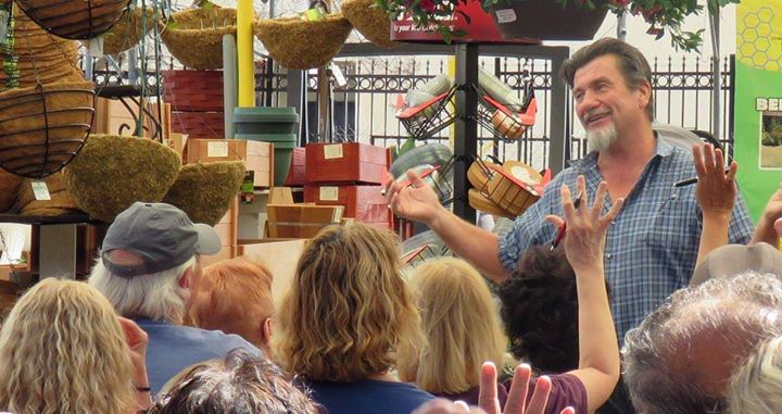 A man is standing in front of a crowd of people at a Southern California garden center.