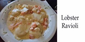 Freshly made lobster ravioli beautifully presented on a white plate.