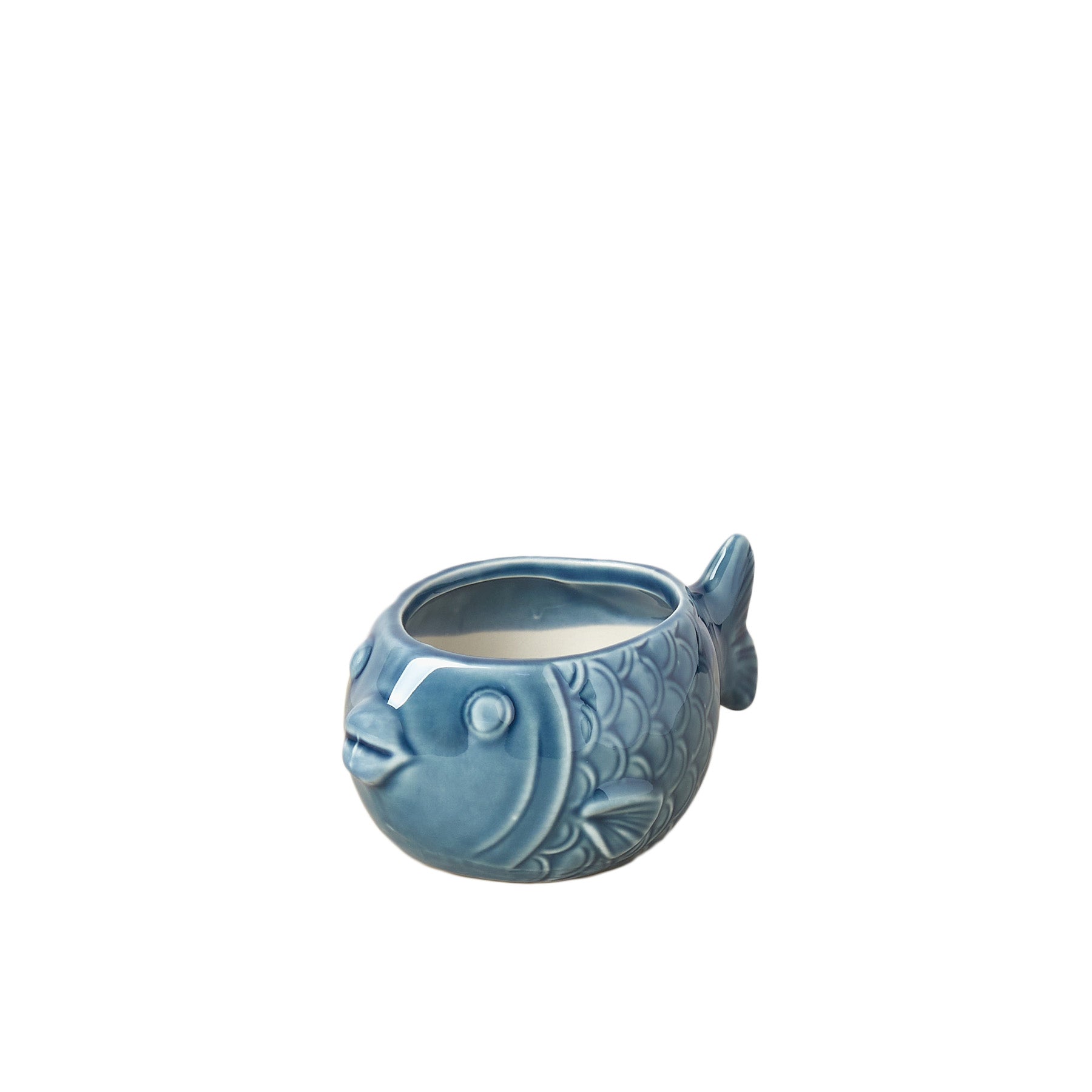 A blue ceramic fish shaped candle holder on a white background in a nursery near me.