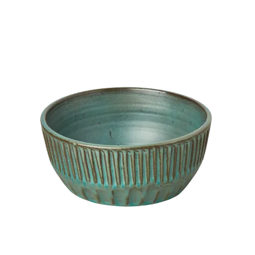 A teal bowl on a black background at one of the best garden nurseries near me.