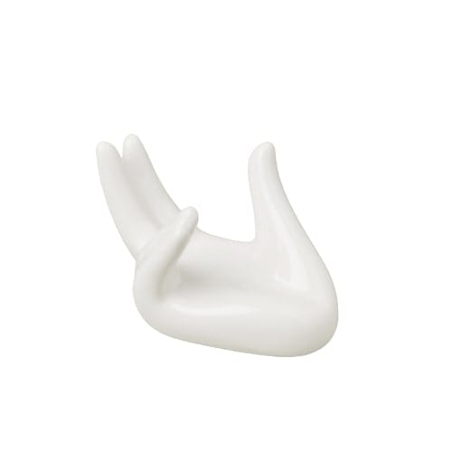 A white ceramic hand shaped object on a white surface, placed elegantly in a garden nursery.