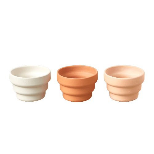 Three vibrant-colored pots on a sleek black background.