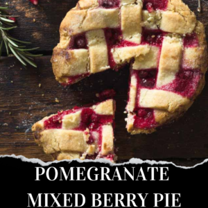 A lattice-topped pie with a slice removed, showing a red pomegranate and mixed berry filling on a dark wooden surface, garnished with rosemary.