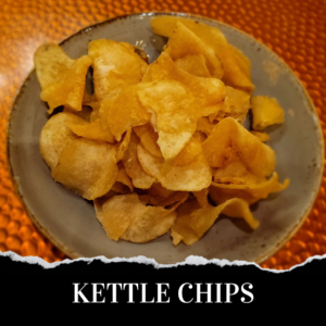 Kettle chips in a bowl on a table.