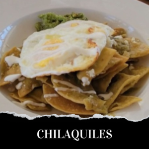 A plate of chilaquiles with an egg and guacamole.